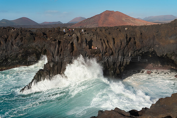 Turistas explorando Los Hervideros - Costa de Yaiza.