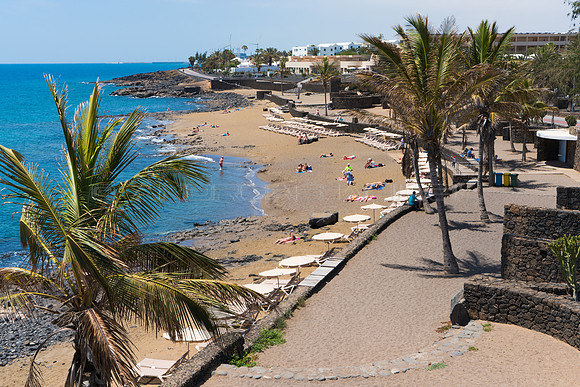 Vista entre palmeras a Playa Bastián - Costa Teguise.
