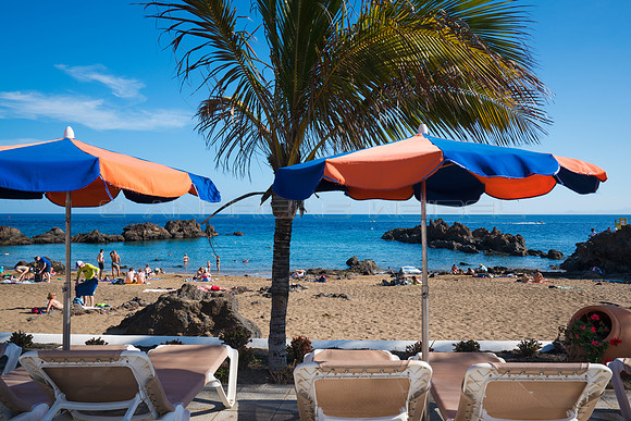 Hamacas con sombrillas ante Playa Chica - Puerto del Carmen, Tí