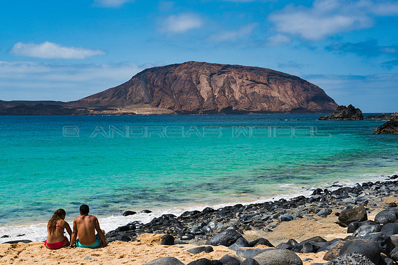 Pareja en la Playa de Las Conchas con Montaña Clara al fondo -