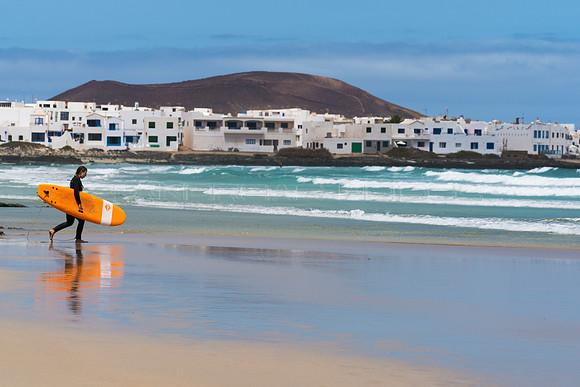 Surfer ante la "Skyline" de la Caleta de Famara - Teguise.