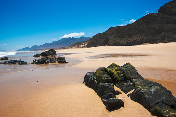 Playa de Cofete con rocas y risco
